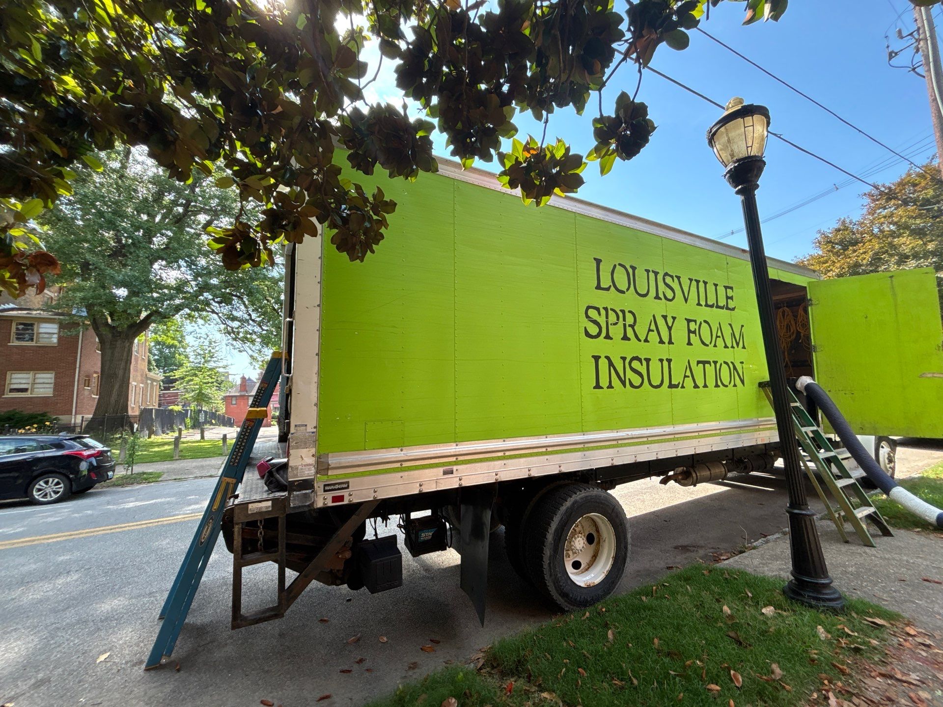 green louisville insulation truck on a summer day